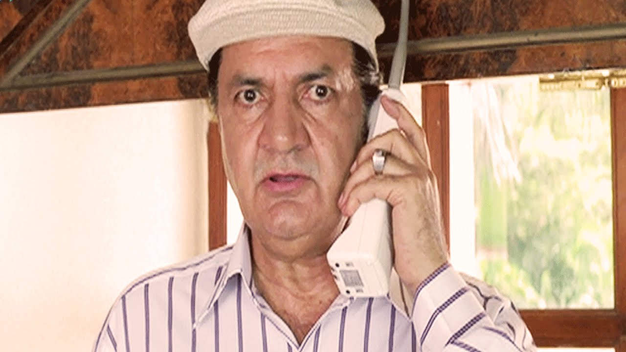 Prem Chopra Holding Phone